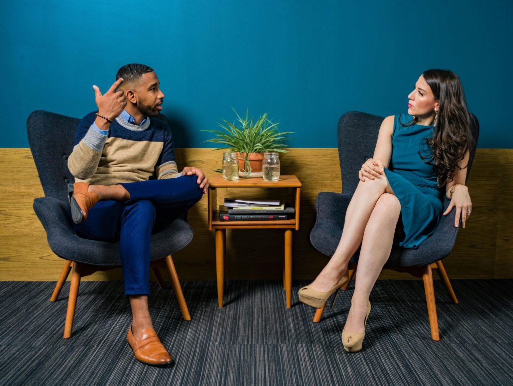 a photo of two young adults in chairs having a discussion that looks intense but not threatening