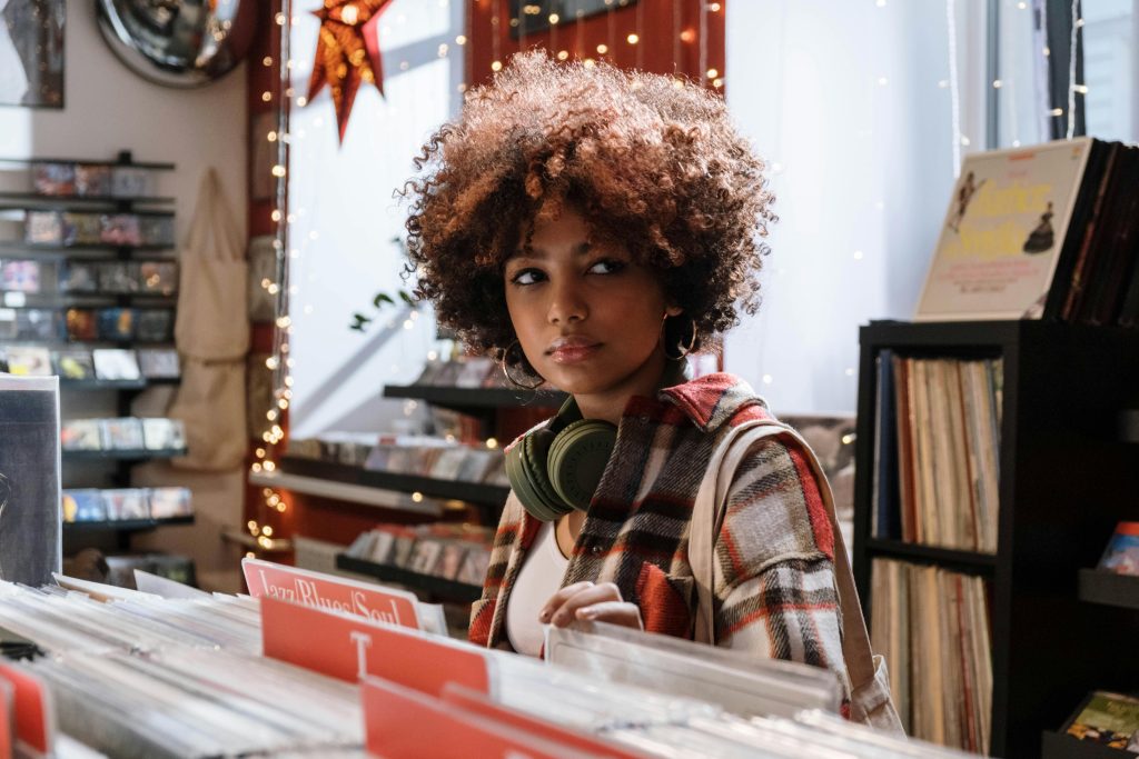 photo of a woman browsing records at a music store, flipping through the jazz/soul genre