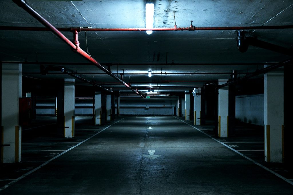 image of an ominously dark and empty parking garage