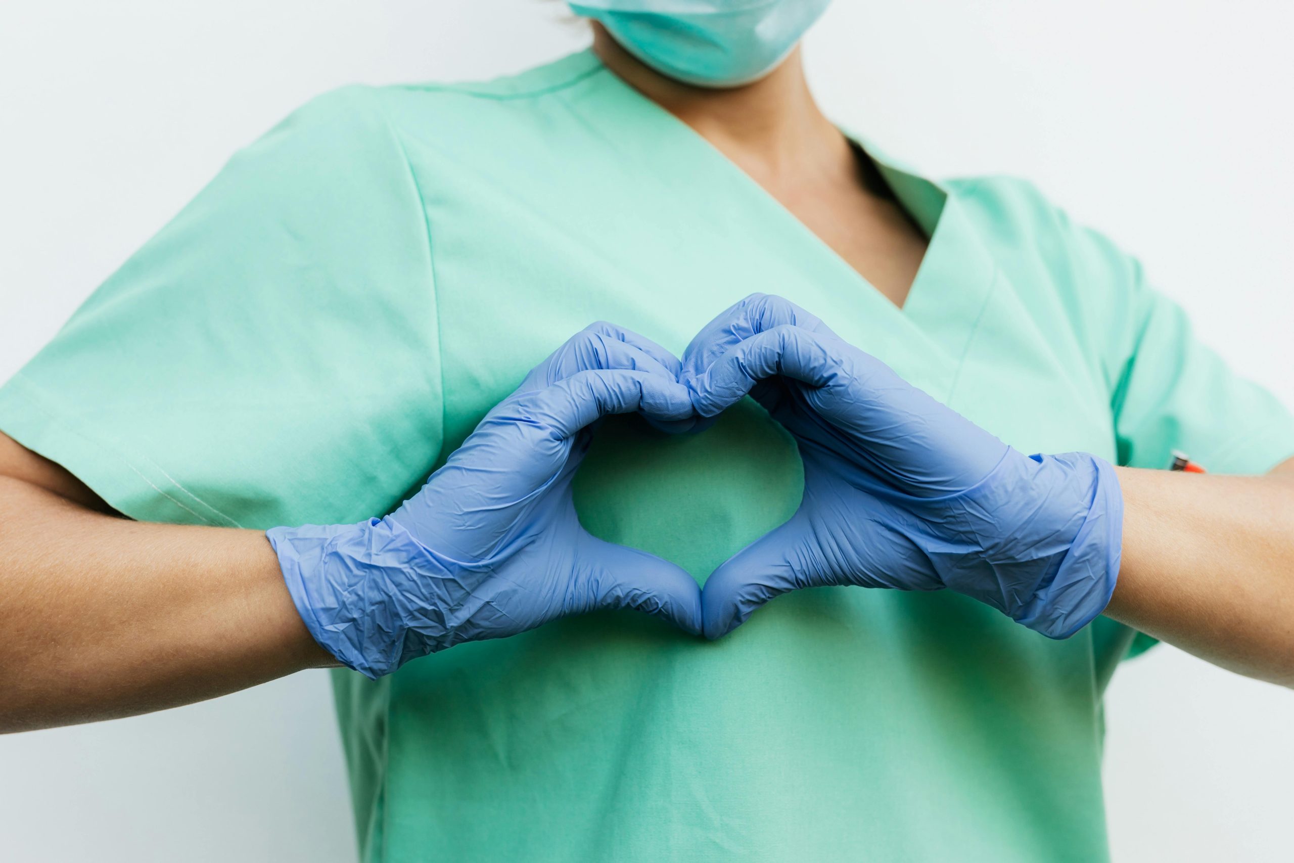 Nurse making heart with hands over her heart