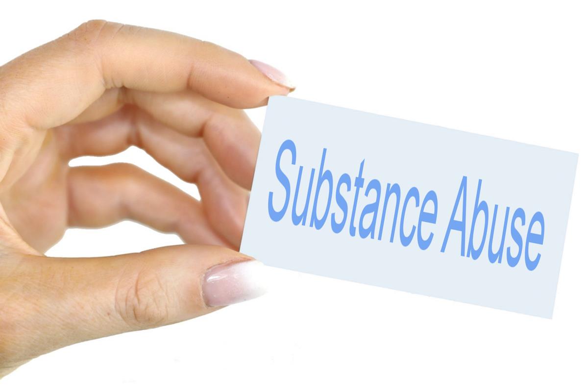 Image of a hand holding a card that reads Substance Abuse