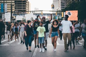 Photograph of people partaking in a Black Lives Matter Protest holding signs.