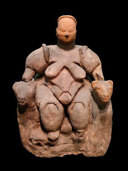 Photograph of a clay, so-called, “Venus figurine” of a heavy woman, naked, sitting.
