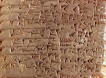 This is a photo showing a cuneiform tablet showing tiny wedged shaped marks indented into a clay tablet.
